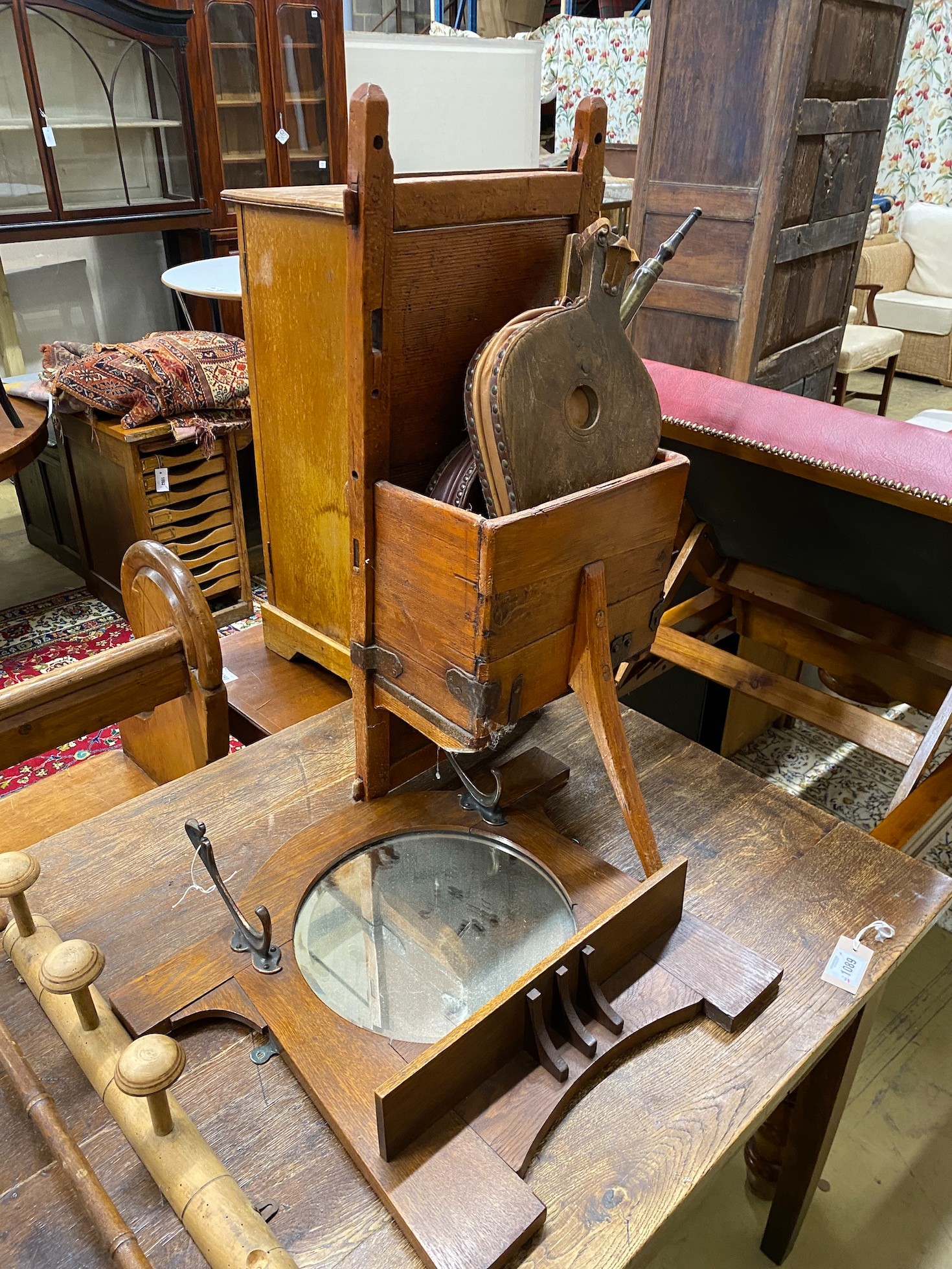 A hall mirror, two late Victorian beech coat racks, a hanging rail, two pairs of bellows, and a cheese carrier